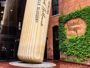 An miage of the front facade of the Louisville Slugger factory. It is a giant baseball bat that appears to be leaning against the building.